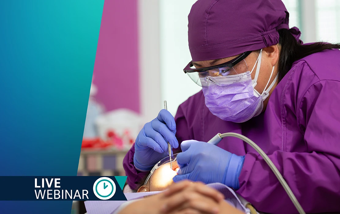Dental professionals in purple surgical cap and scrubs performing a procedure using dental tools on a patient