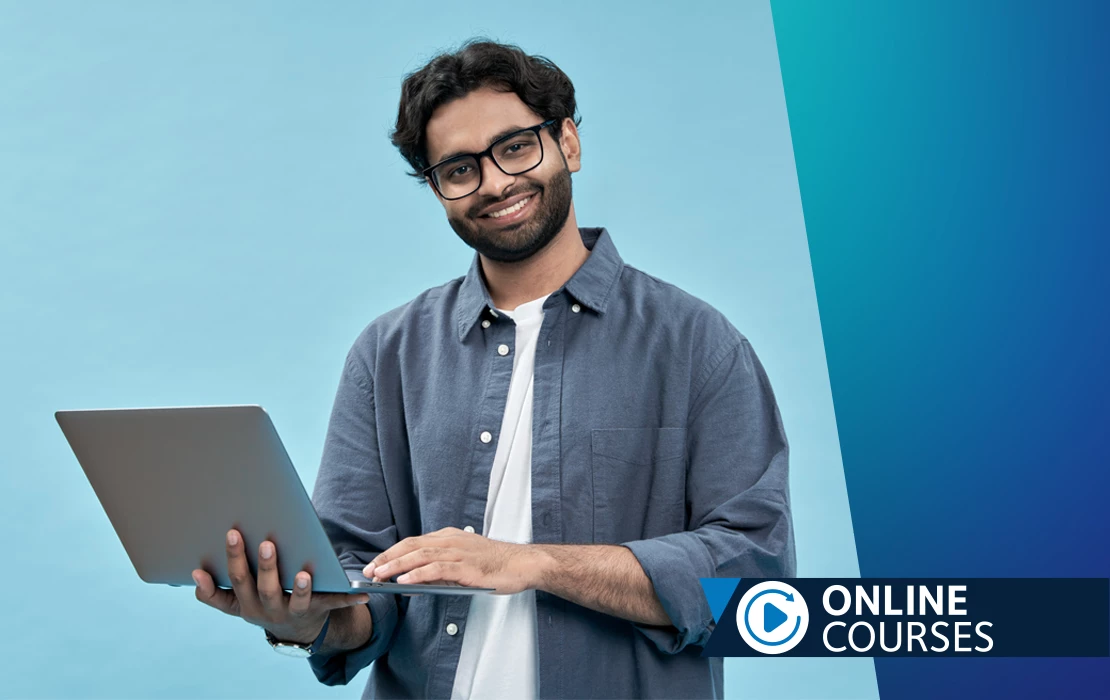 Man in scrubs sitting in front of a laptop
