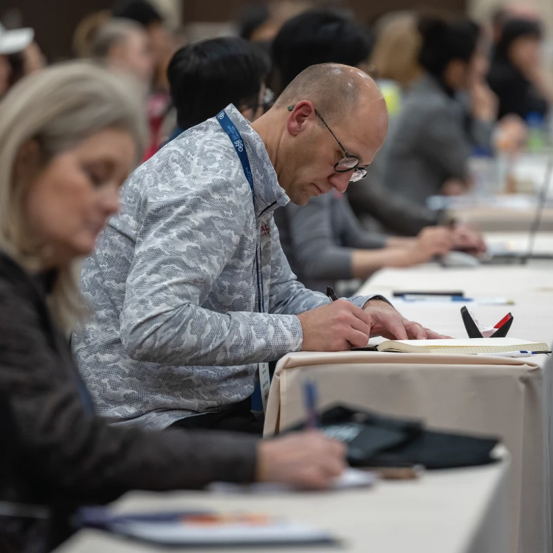 Group of attendees listening to poster presentation