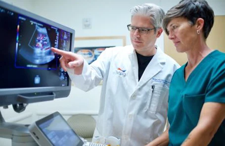 male and women doctor looking at medical computer screen ultrasound